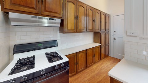 a kitchen with wooden cabinets and white counter tops and a stove top oven